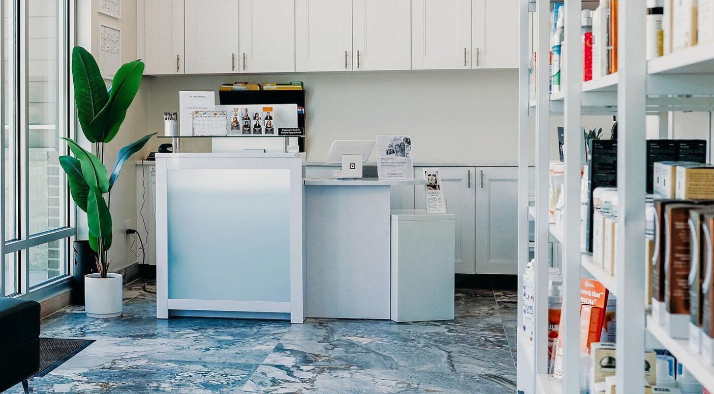 Reception area at Vogue Lashes & Spa - Greenbrier, Chesapeake, Virginia, US with modern decor and open shelving.