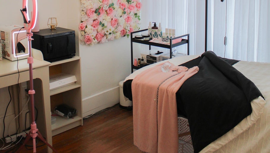 Get Up and Glow Beauty Studio room, Chehalis, WA; serene setup with bed, floral decor, and beauty products.