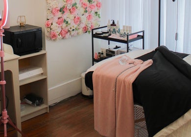 Get Up and Glow Beauty Studio room, Chehalis, WA; serene setup with bed, floral decor, and beauty products.