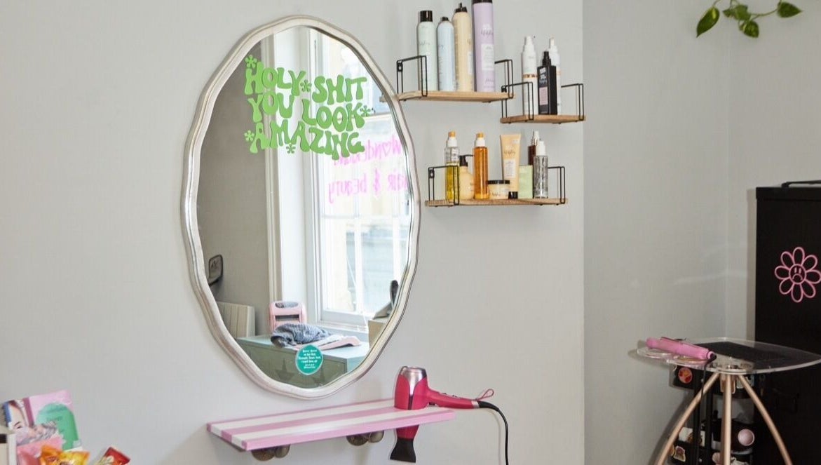 Elegant styling station at Wonderland Hair Cheltenham, Cheltenham, England, GB with mirror and hair products.
