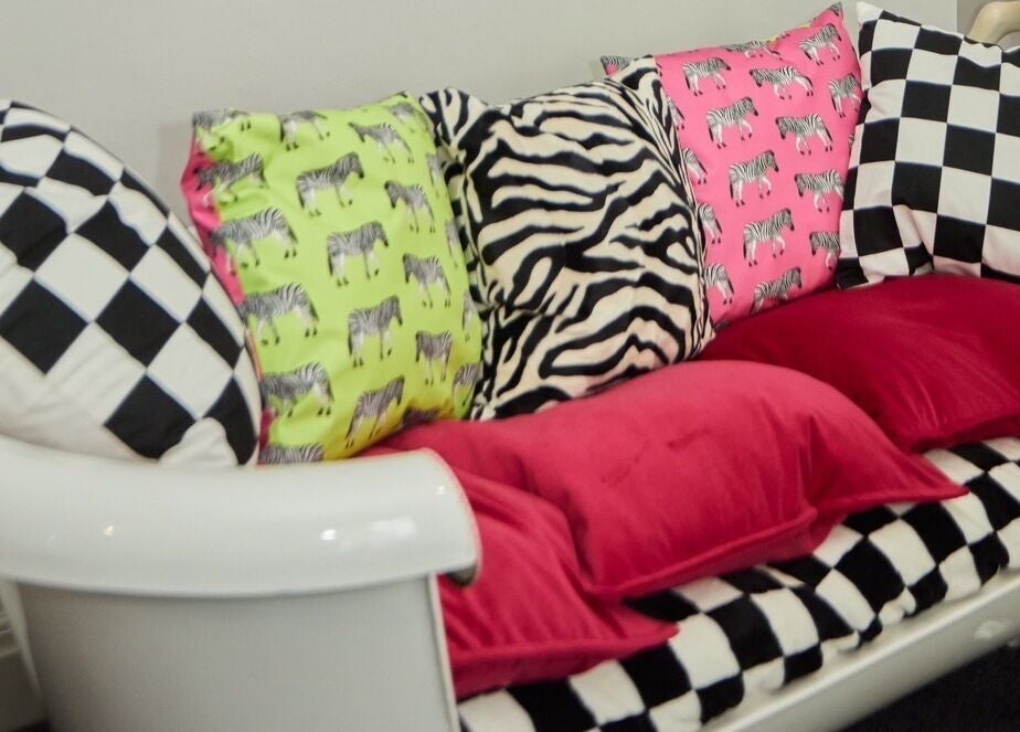 Bright, patterned cushions on a sofa at Wonderland Hair Cheltenham, Cheltenham, England, GB.
