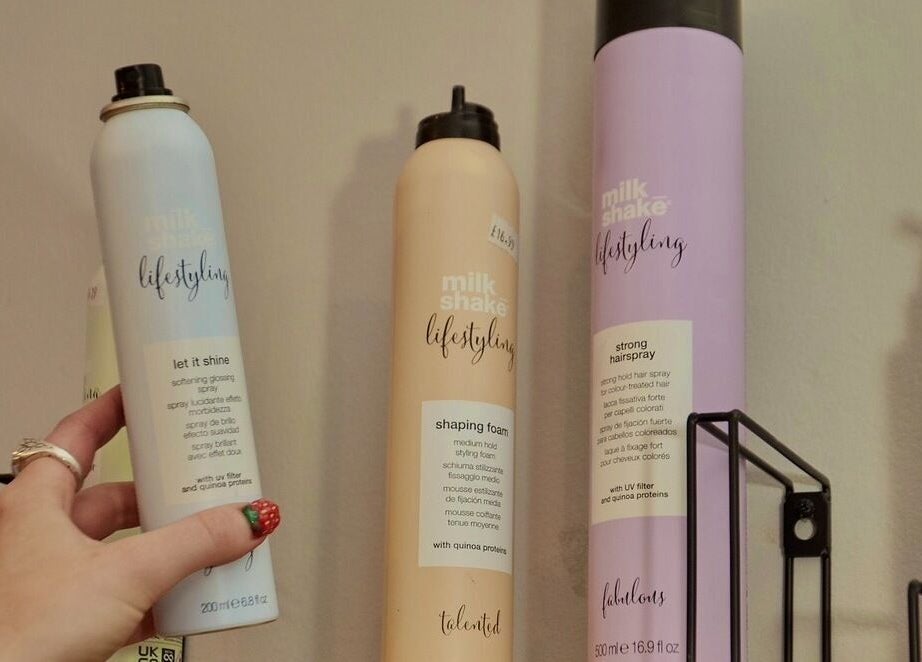 Hair styling sprays at Wonderland Hair Cheltenham, England, GB, highlighting premium hair care products.