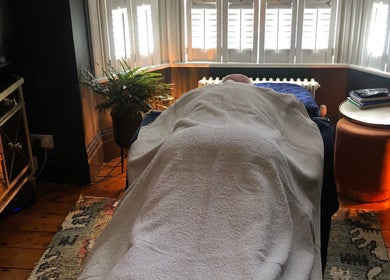 Tranquil massage room at The Body Massage Guru, Manchester, England, GB with a client on the table.
