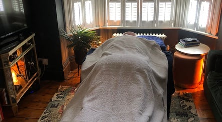 Tranquil massage room at The Body Massage Guru, Manchester, England, GB with a client on the table.