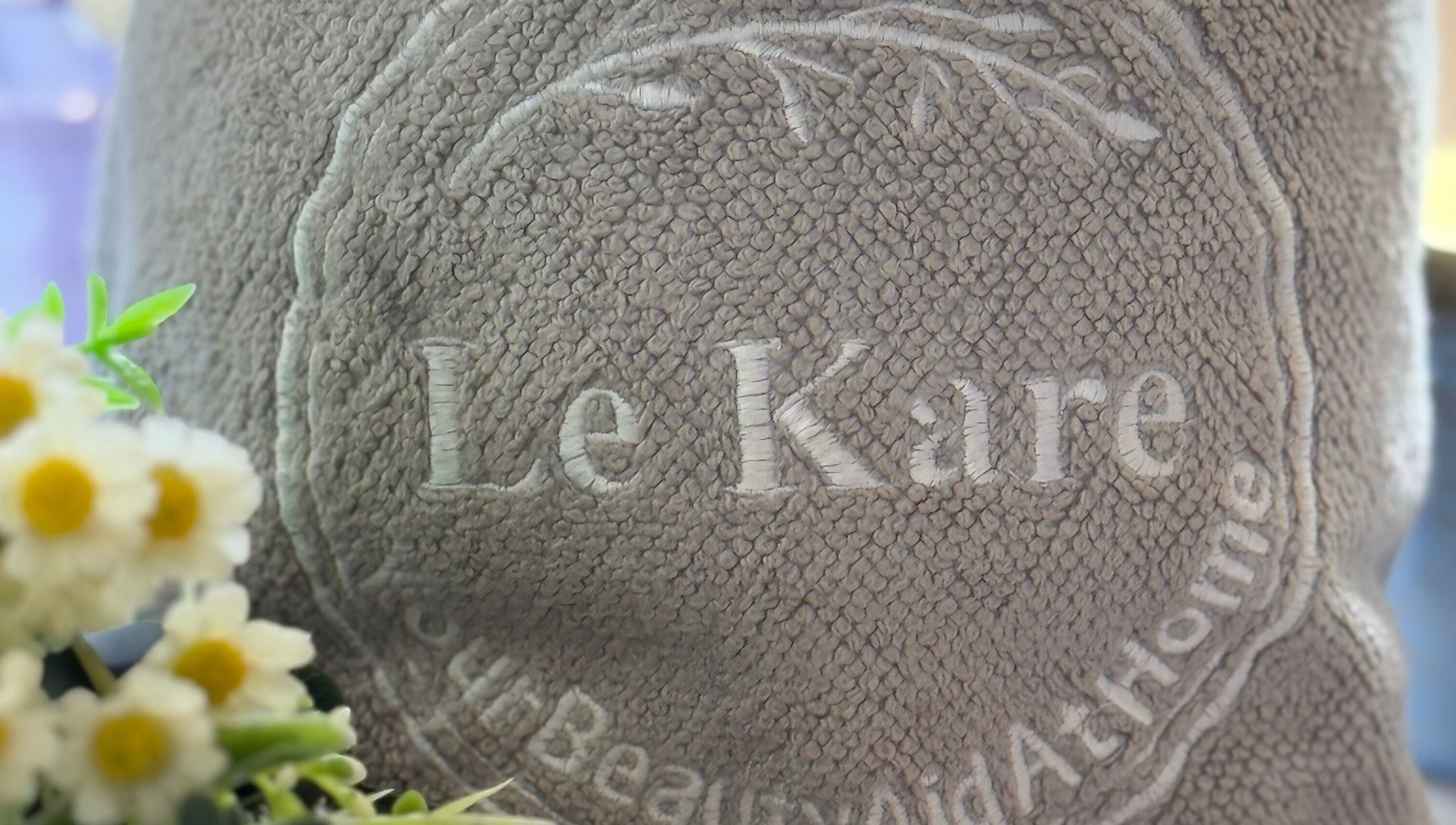 Le Kare Spa - Home Service Jeddah logo on plush towel in Jeddah, SA, showcasing premium spa experience.