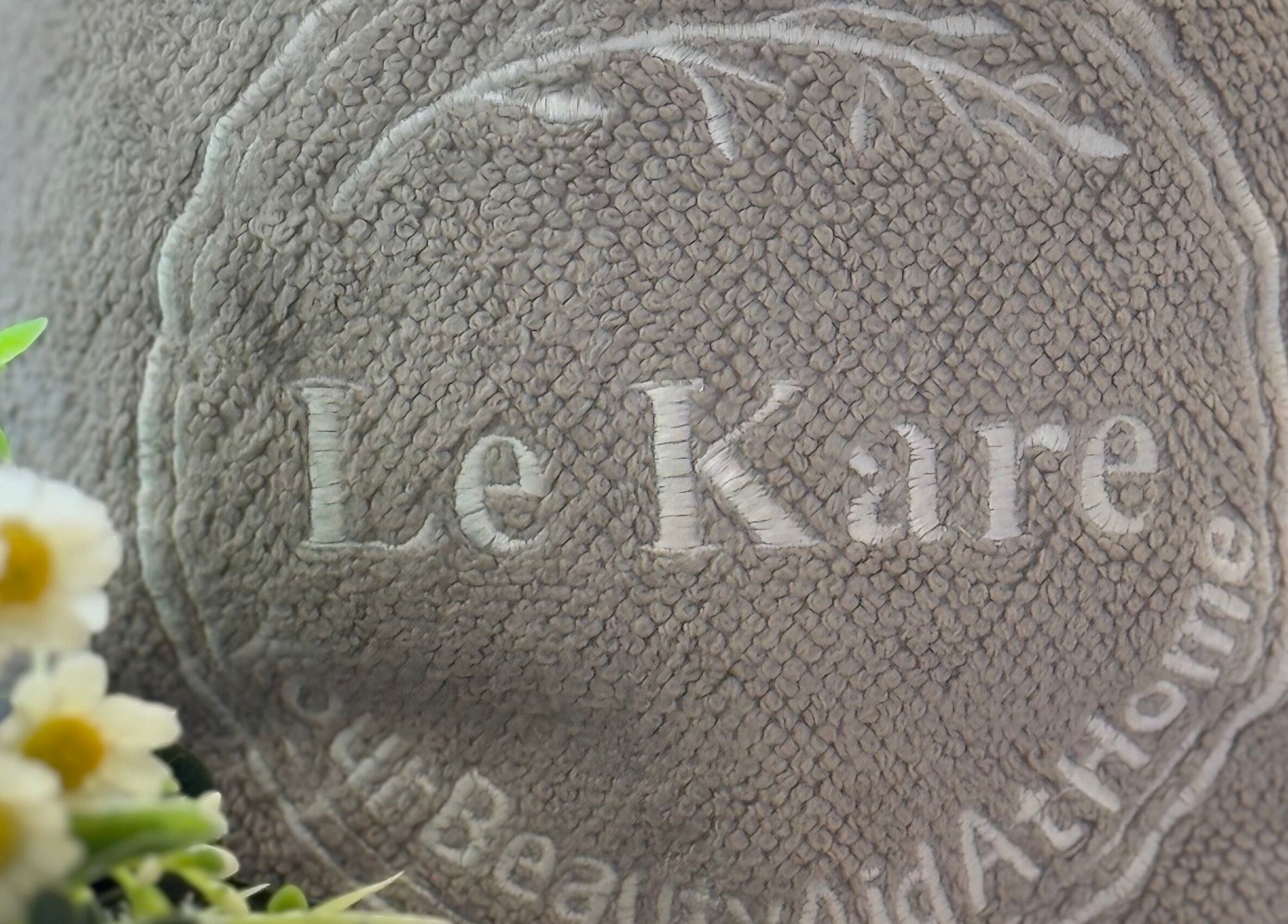 Le Kare Spa - Home Service Jeddah logo on plush towel in Jeddah, SA, showcasing premium spa experience.