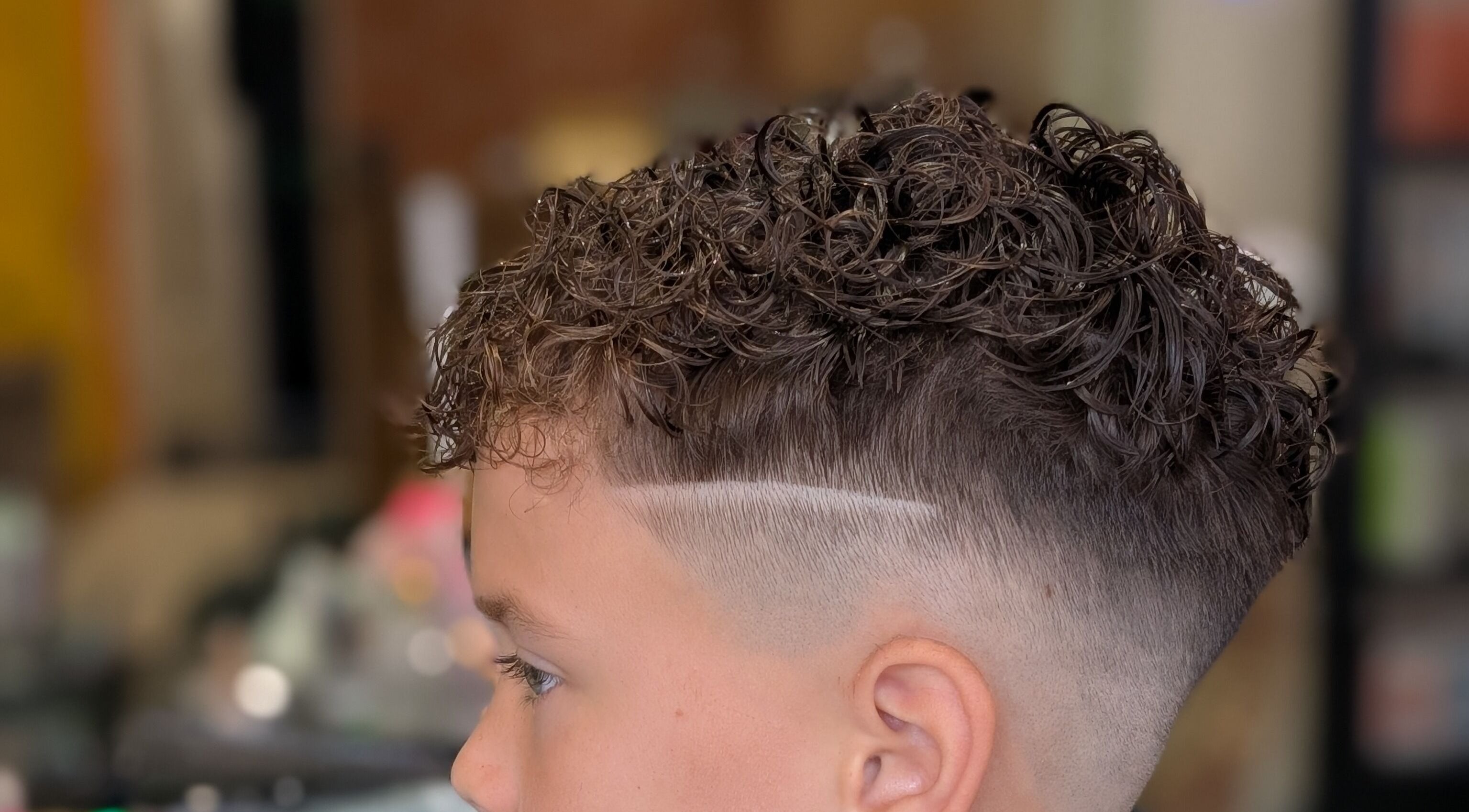 Styled curly haircut at Sandi Hair Studio, Greater, Atherton, England, GB. Trendy salon experience.