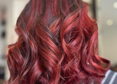 Vibrant red curls styled at Sandi Hair Studio in Greater, Atherton, England, GB.