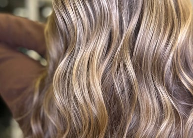 Elegant wavy hair styled at Sandi Hair Studio, Greater, Atherton, England, GB, showcasing glossy blonde highlights.