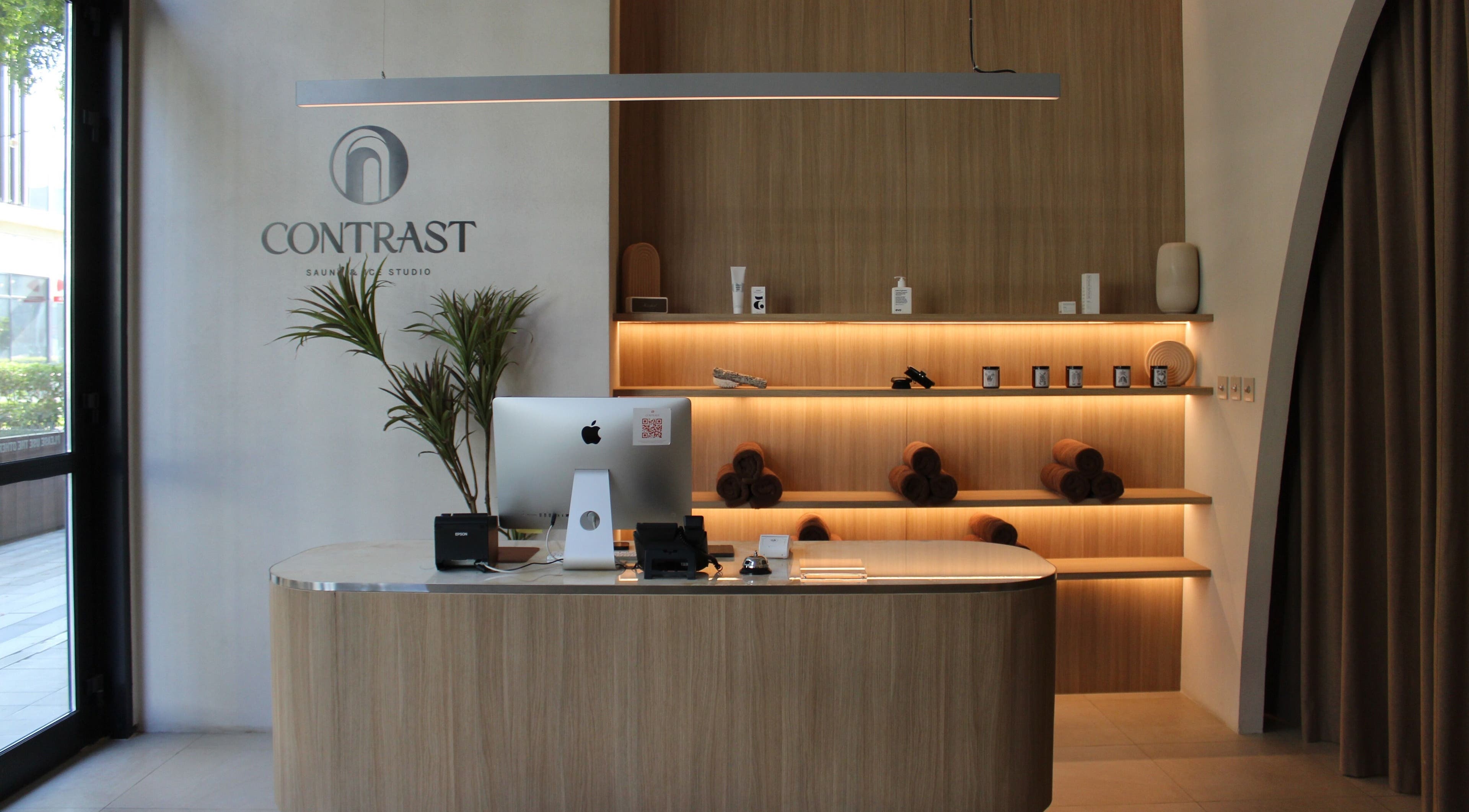 Reception area of Contrast City Walk in Dubai, Dubai, AE with stylish wooden decor and ambient lighting.