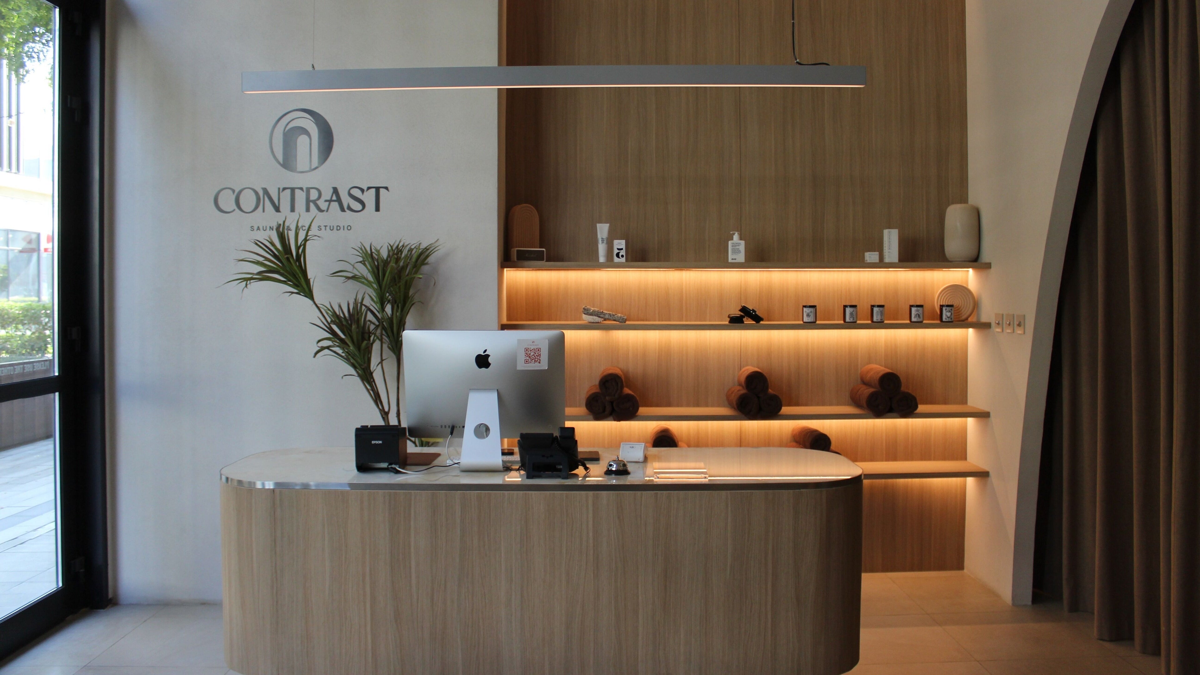 Reception area of Contrast City Walk in Dubai, Dubai, AE with stylish wooden decor and ambient lighting.