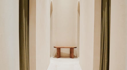 Arched hallway with wooden bench at Contrast Palm Jumeirah, Dubai, Dubai, AE, offering serene elegance.