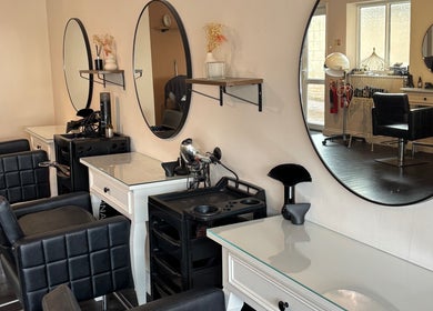 Elegant salon setup at Inspire Nails, Studley, England, GB featuring stylish black chairs and large round mirrors.
