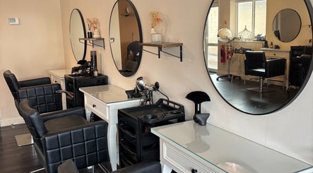 Elegant salon setup at Inspire Nails, Studley, England, GB featuring stylish black chairs and large round mirrors.