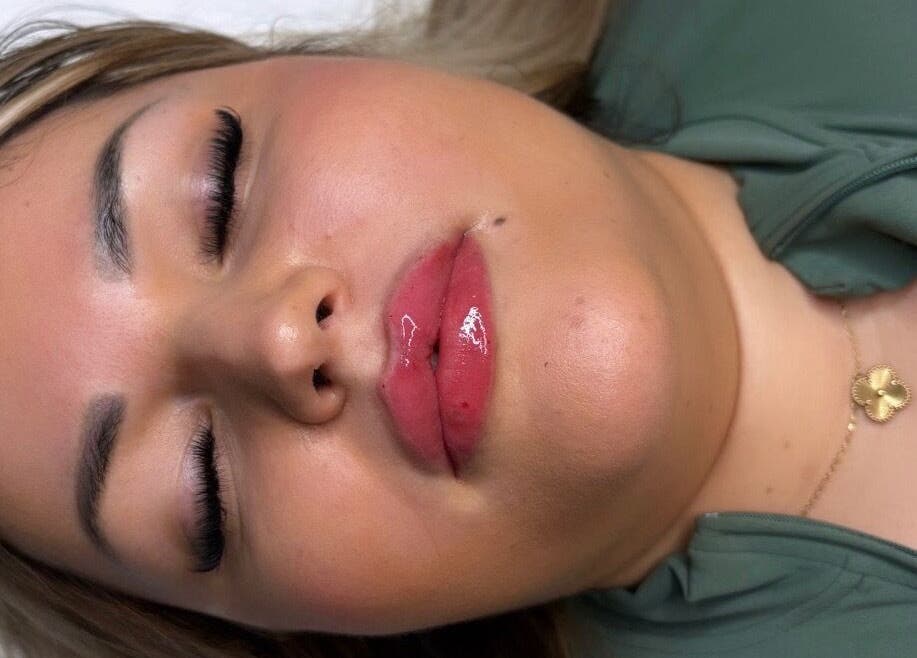 Close-up of a woman with glossy lips at Deebeautystop, London, England, GB.