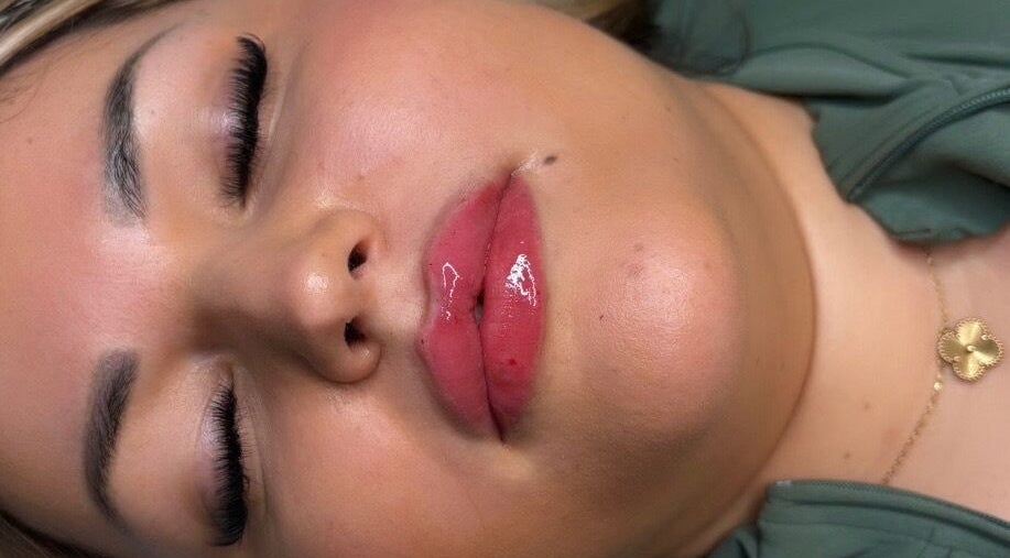 Close-up of a woman with glossy lips at Deebeautystop, London, England, GB.