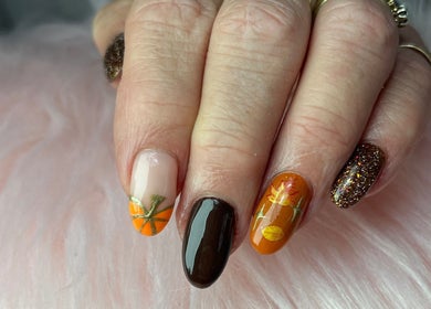 Close-up of autumn-themed nails at Nails by Freya (Prestatyn), showcasing orange and brown designs in Prestatyn, Wales, GB.