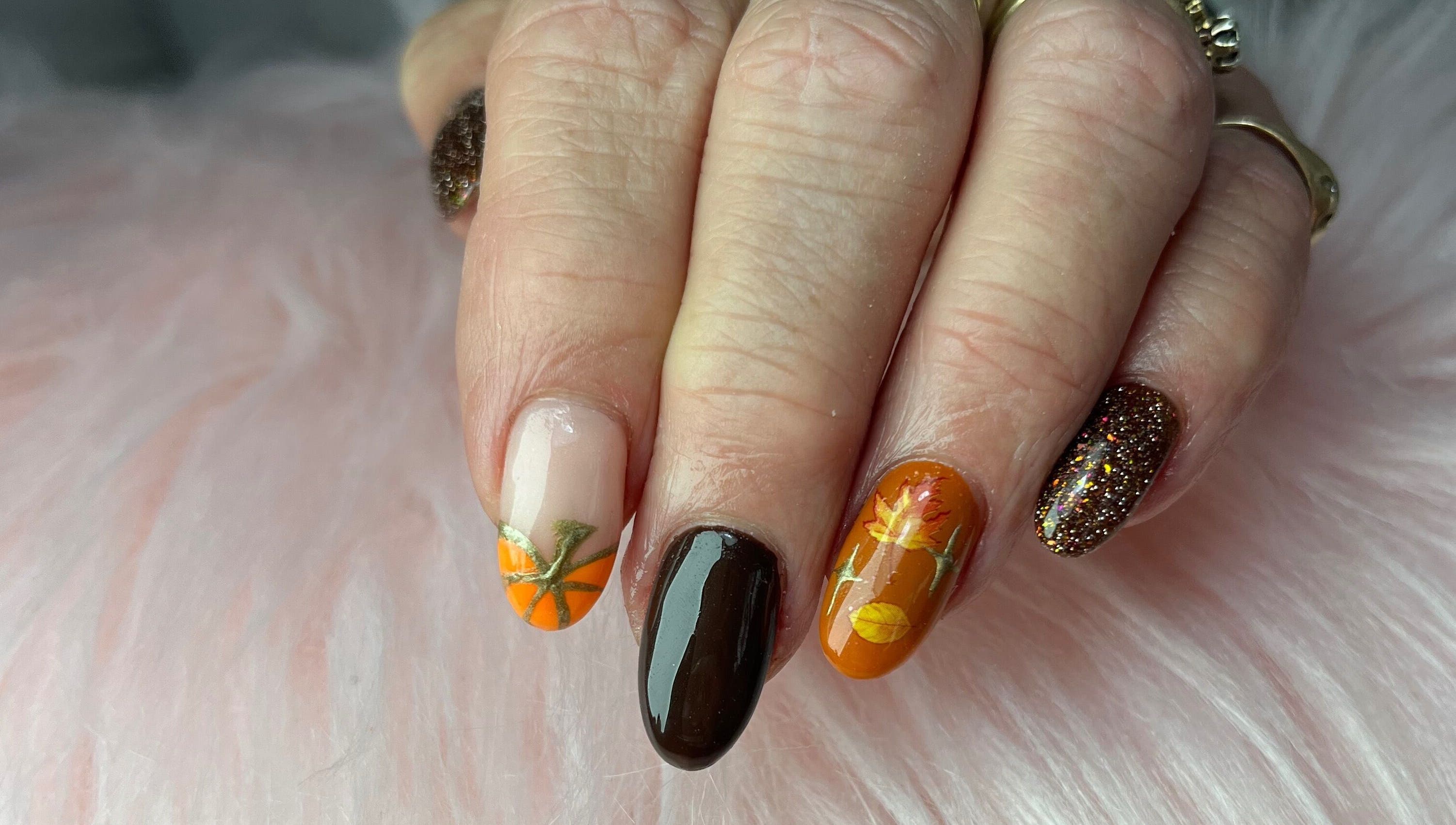 Autumn-themed nails with glitter at Nails by Freya, Prestatyn, Wales, GB. Perfect for seasonal charm.