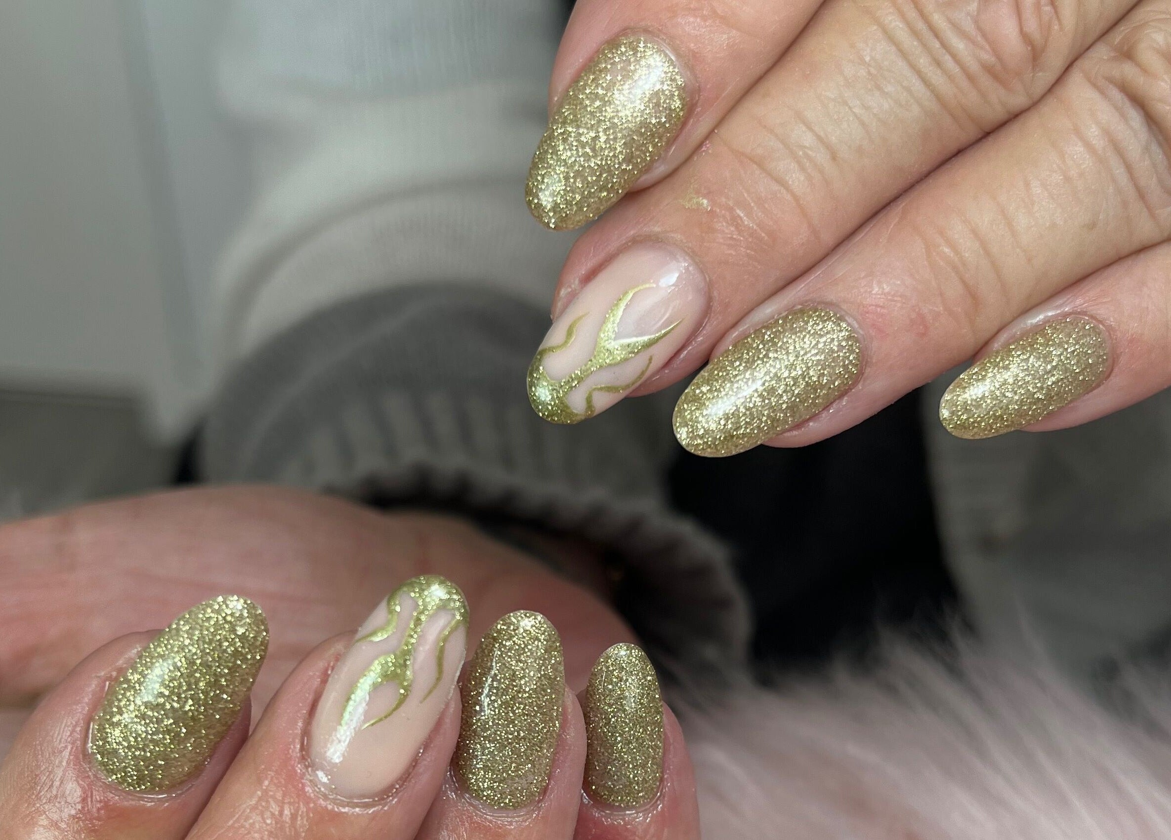 Gold glitter nails with artistic design at Nails by Freya, Prestatyn, Wales, GB.