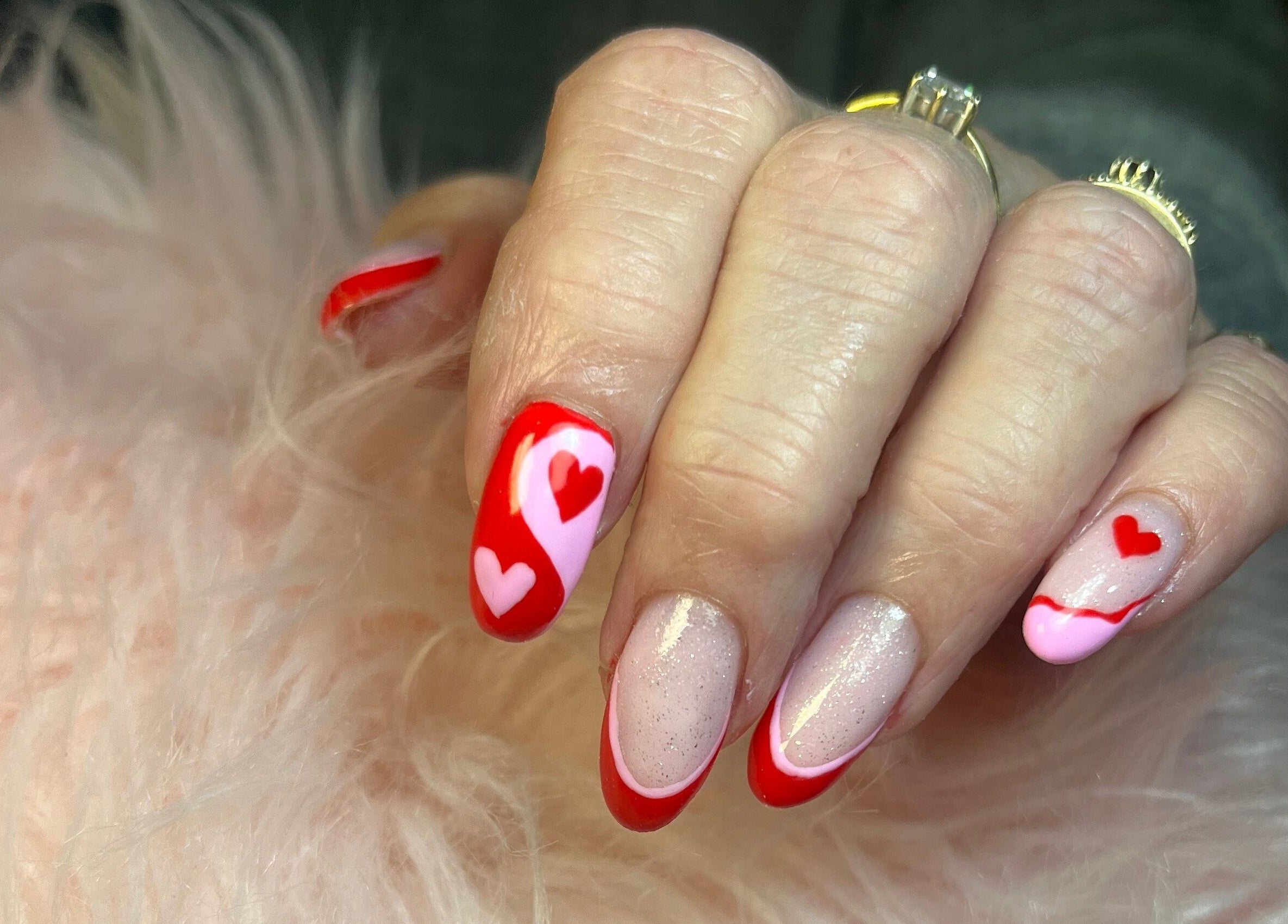 Valentine-themed nail art with red and pink hearts at Nails by Freya (Prestatyn), Prestatyn, Wales, GB.