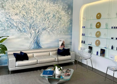 Elegant reception area at Starlight Med Spa Toronto, Ontario, CA with a soothing tree mural and sleek seating.