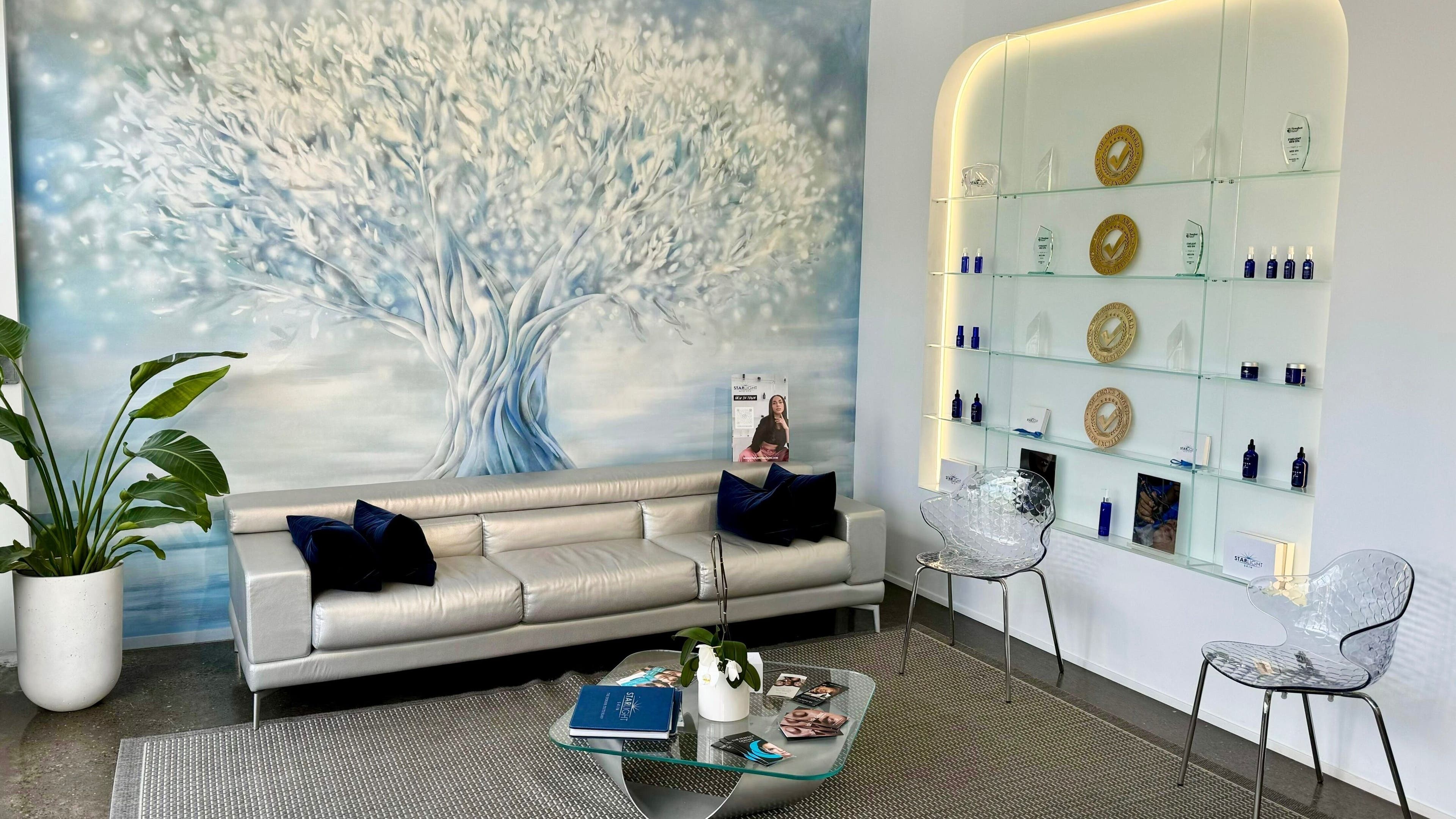 Elegant reception area at Starlight Med Spa Toronto, Ontario, CA with a soothing tree mural and sleek seating.