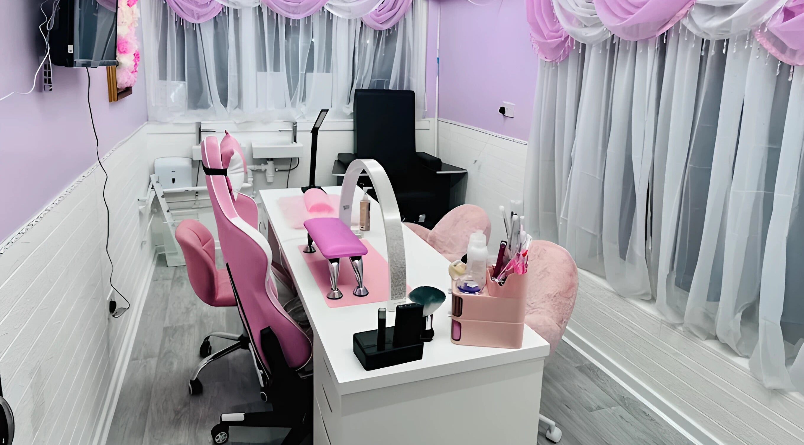 Elegant nail salon at Cariad Beauty, Fauldhouse, Scotland, GB featuring pink decor and chic furniture.