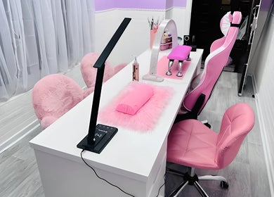 Modern nail station at Cariad Beauty in Fauldhouse, Scotland, GB with pink chairs and sleek decor.