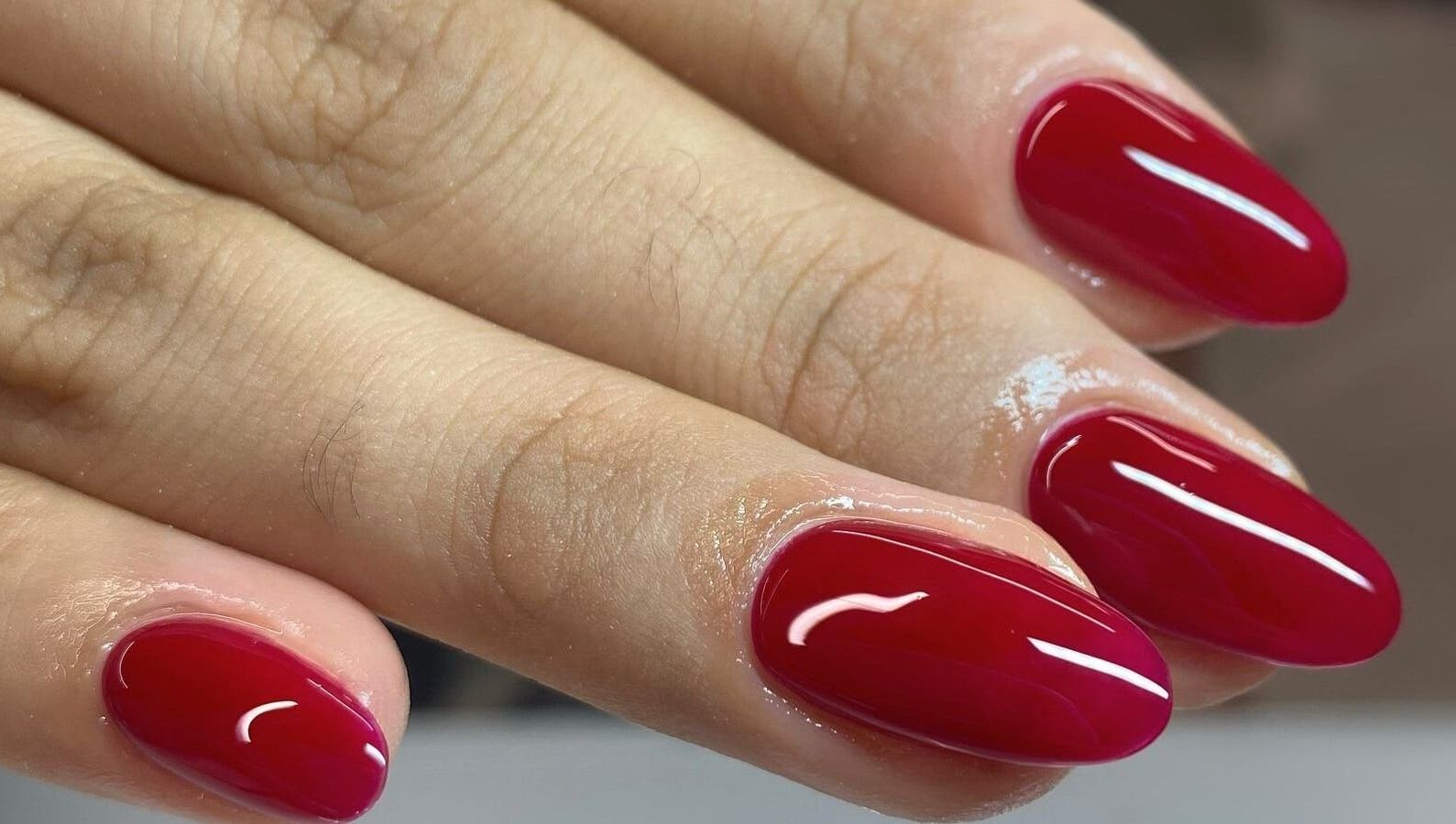 Manicura en Nyla Nail Studio, Chihuahua, Chihuahua, MX con uñas rojas brillantes.