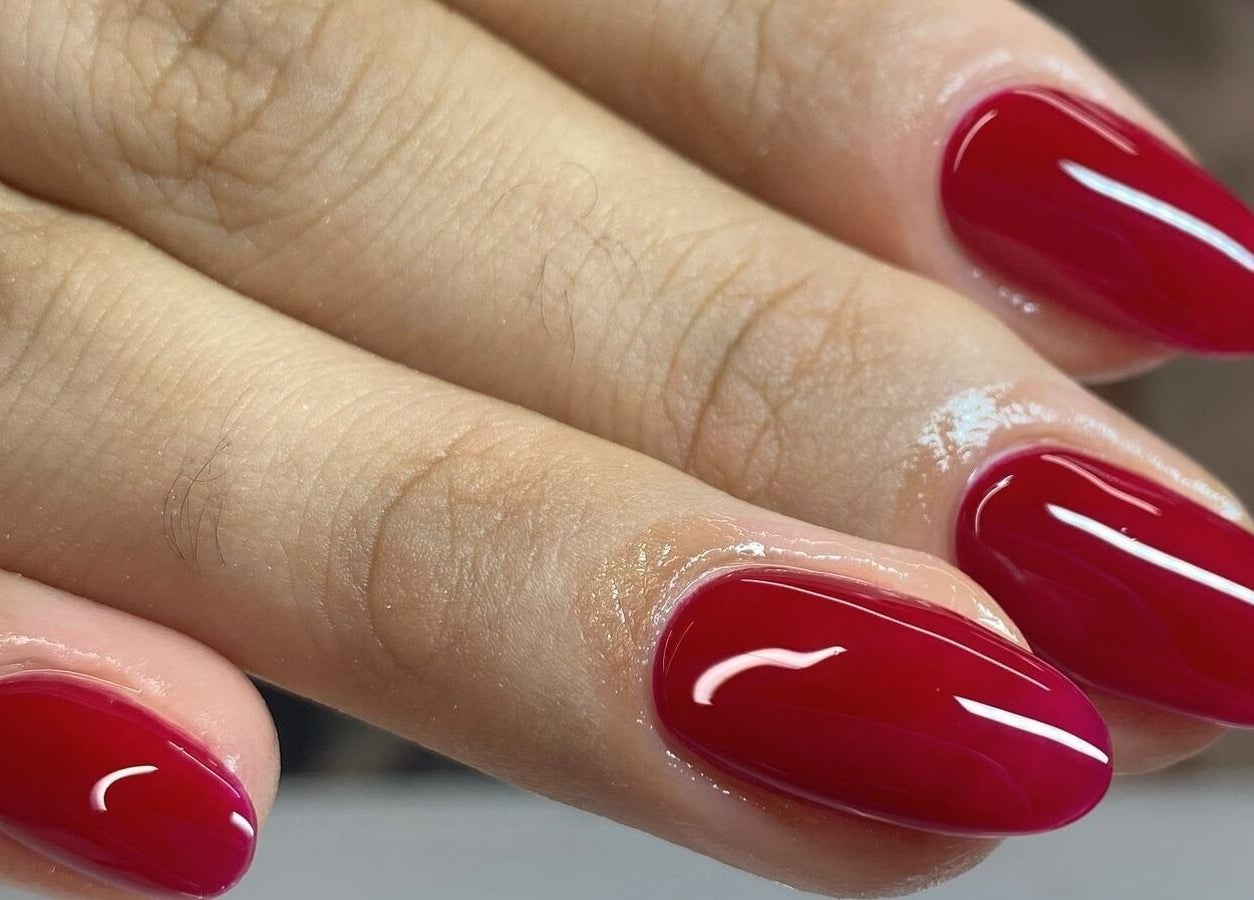 Manicura en Nyla Nail Studio, Chihuahua, Chihuahua, MX con uñas rojas brillantes.