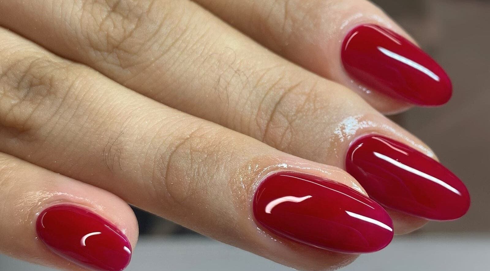 Manicura en Nyla Nail Studio, Chihuahua, Chihuahua, MX con uñas rojas brillantes.