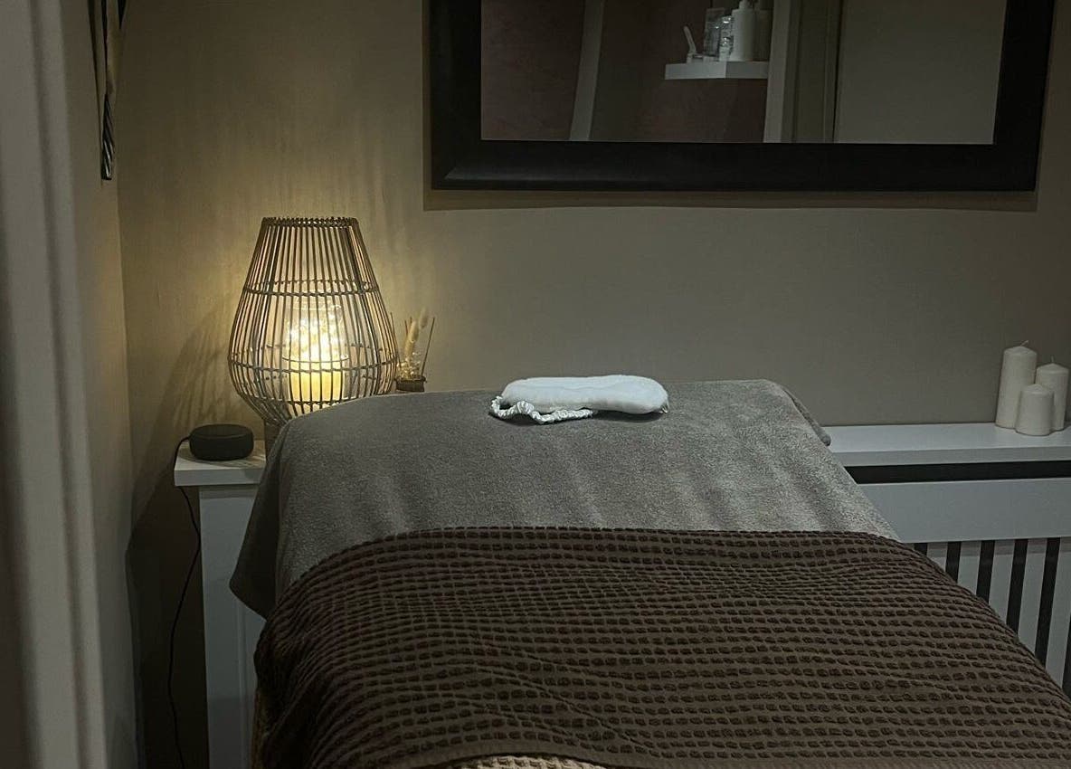 Cozy massage room at Le Roux Beauty in Langford, England featuring warm lighting and elegant decor.