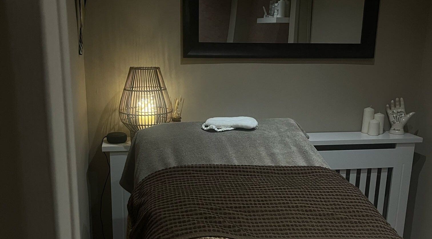 Cozy massage room at Le Roux Beauty in Langford, England featuring warm lighting and elegant decor.