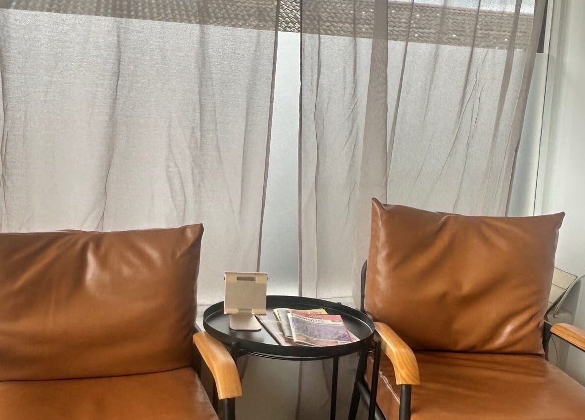 Comfortable seating area at Le Roux Beauty, Langford, England, GB with leather chairs and round table.