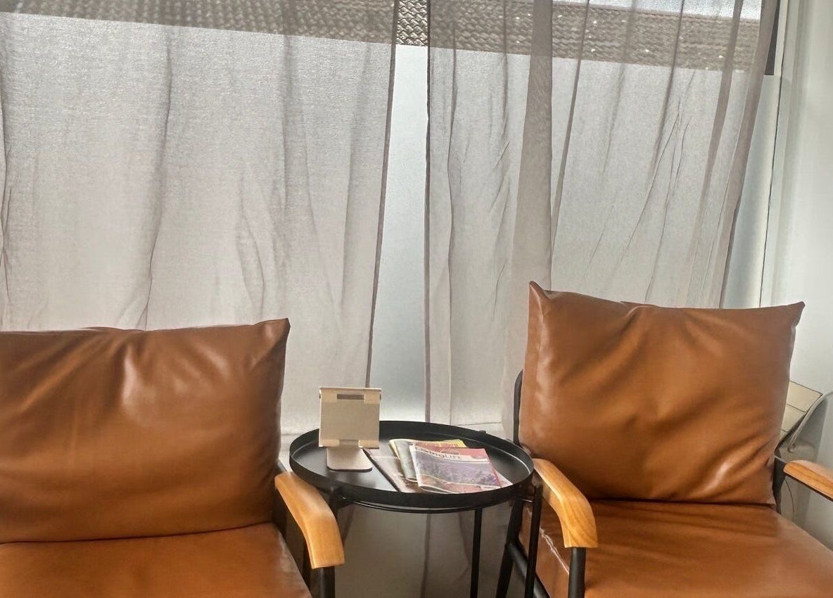 Comfortable seating area at Le Roux Beauty, Langford, England, GB with leather chairs and round table.