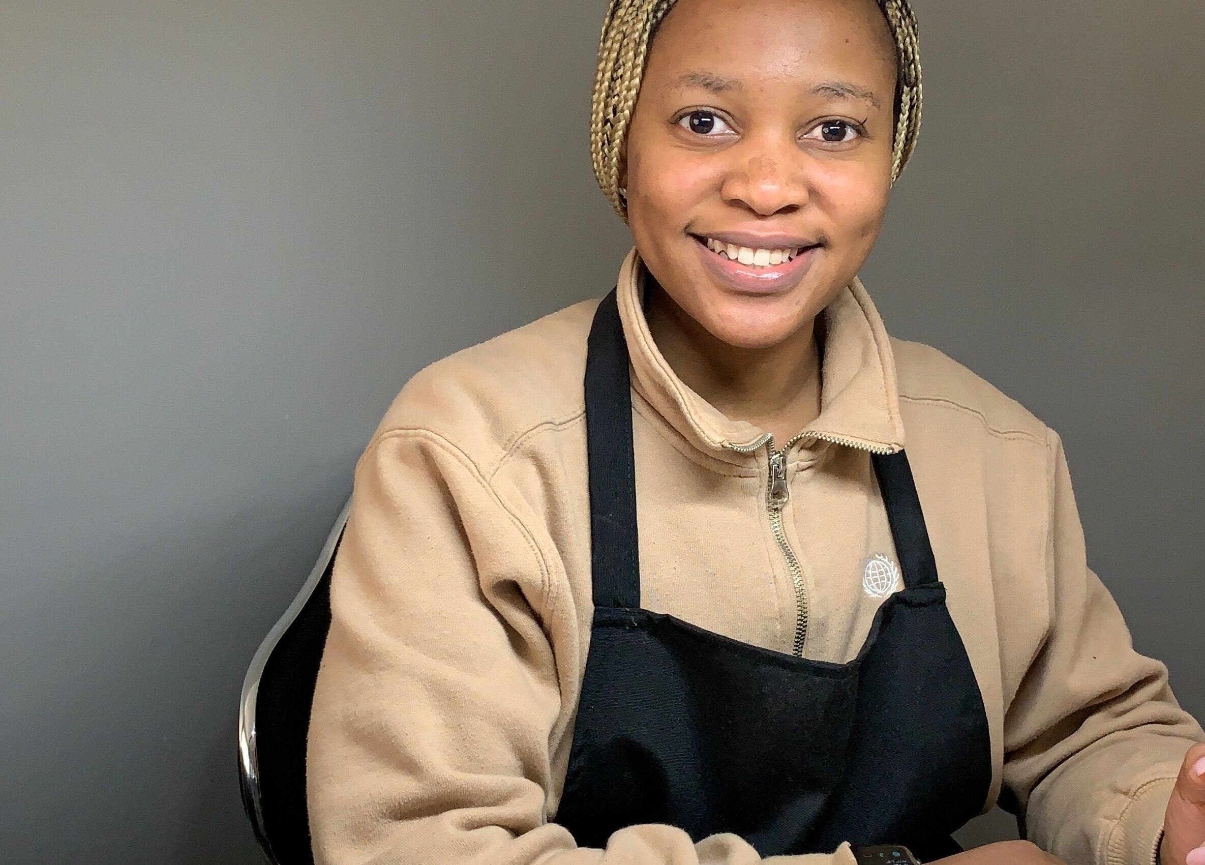 Professional beautician at Nubian Native by Fundo, Randburg, Gauteng, ZA, smiling during a treatment session.