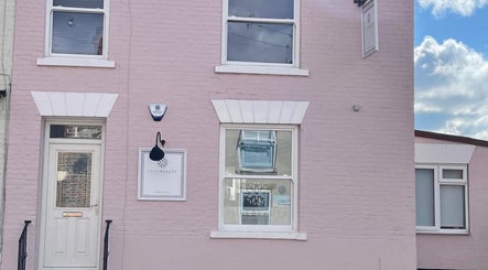 Front view of Pure Beauty & Skincare Roos in Roos, England, featuring a pastel pink exterior.