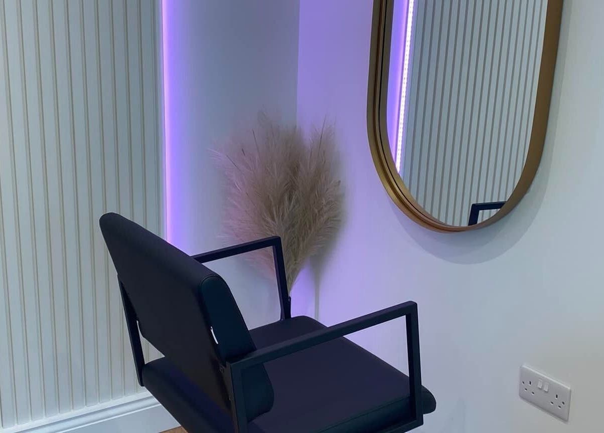 Modern beauty salon corner with chair and round mirror at Nóvara, Rochford, England, GB.