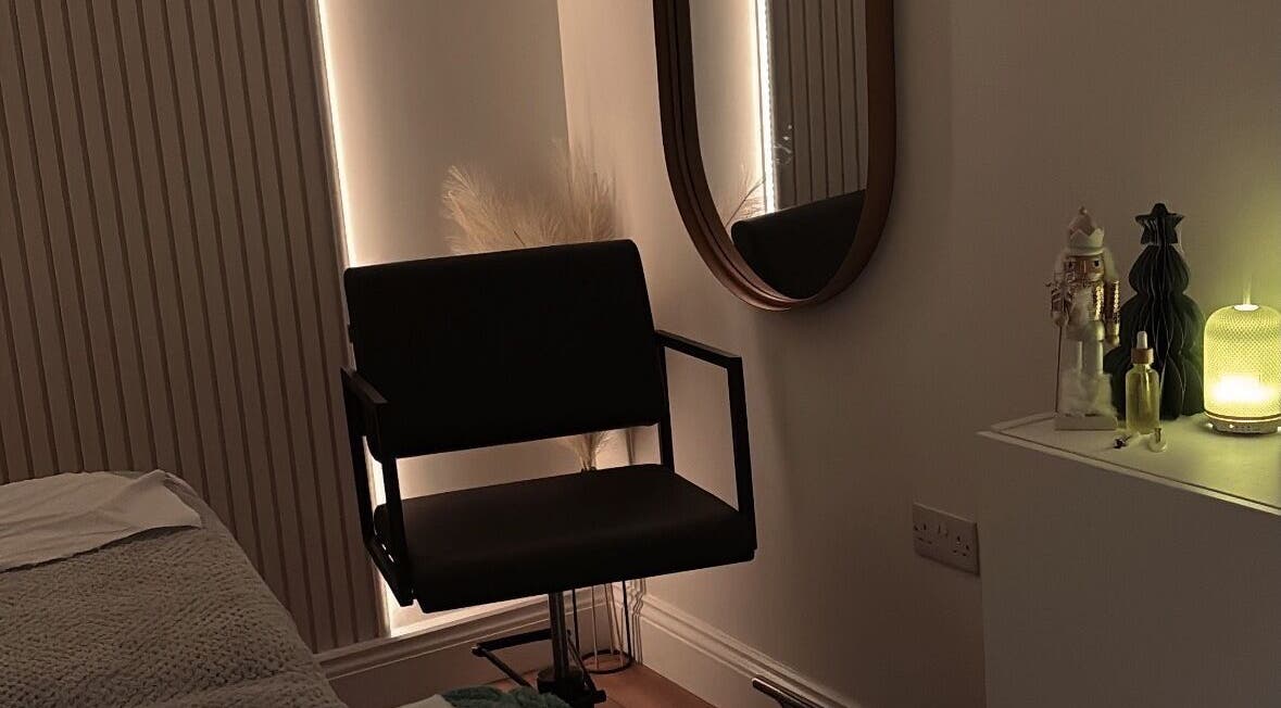 Elegant salon corner at Nóvara in Rochford, England, GB with a plush chair and subtle lighting.