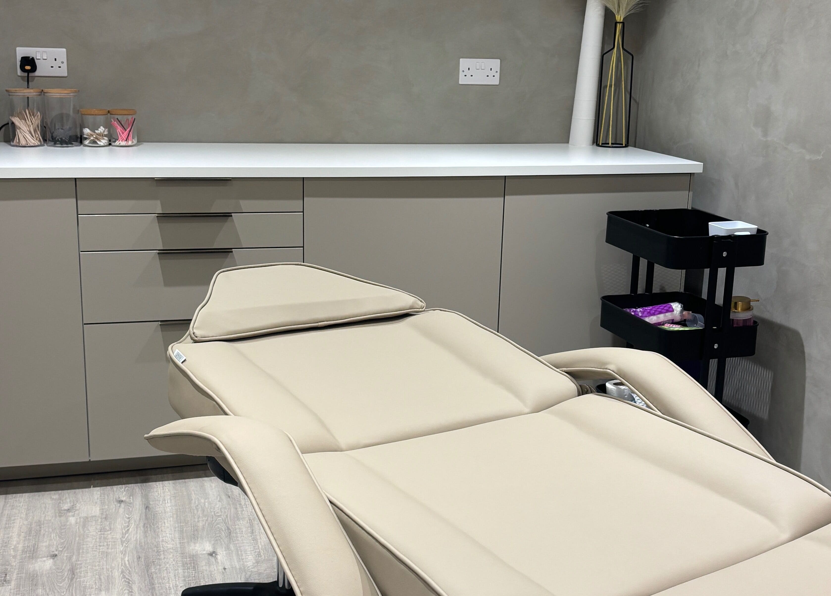 Elegant treatment room at Nóvara, Rochford, England, GB, featuring a comfortable beige chair.