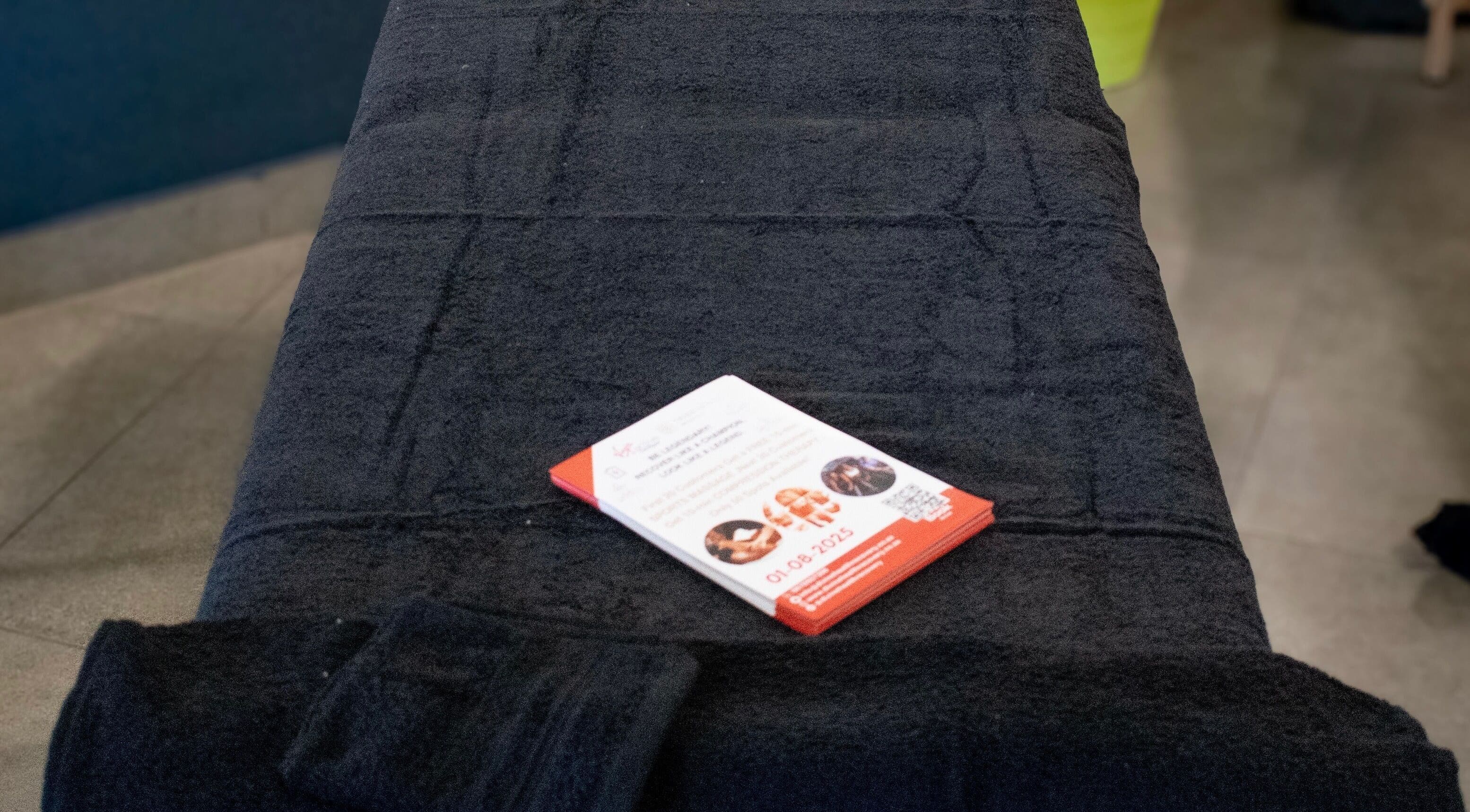 Pamphlet on black massage table at Divine Health Recovery, Randburg, Gauteng, ZA.