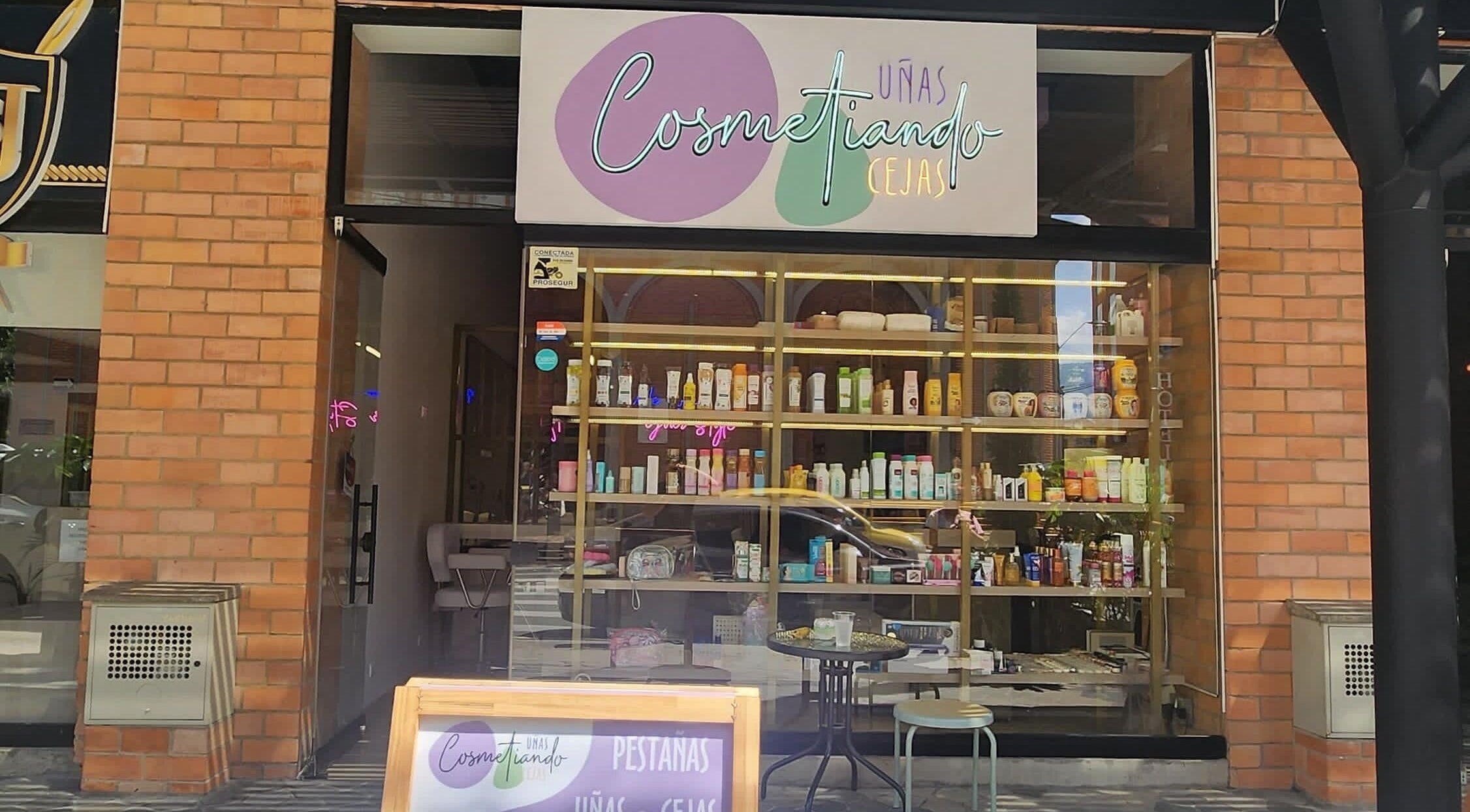 Fachada de Cosmetiando en Medellín, Antioquia, CO, mostrando productos de belleza en el escaparate.