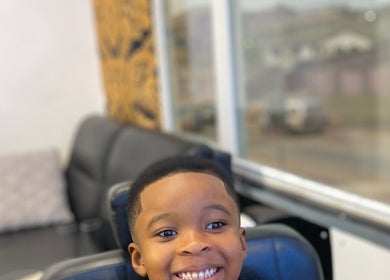 Child smiling at Polished - Chic, stylish salon in Kumasi, Ashanti Region, GH, offering pleasant beauty services.