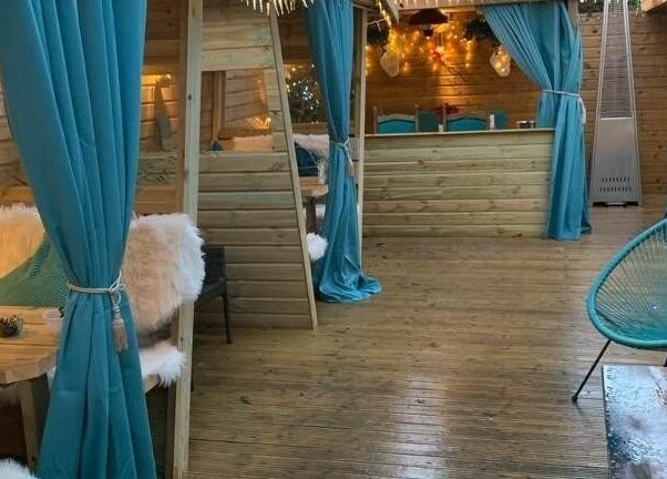 Inviting lounge with teal drapes and wood decor at Achill Spa in Knowle, England, GB.