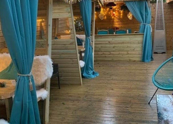 Inviting lounge with teal drapes and wood decor at Achill Spa in Knowle, England, GB.