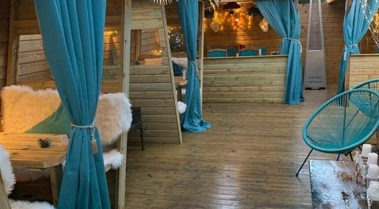 Inviting lounge with teal drapes and wood decor at Achill Spa in Knowle, England, GB.