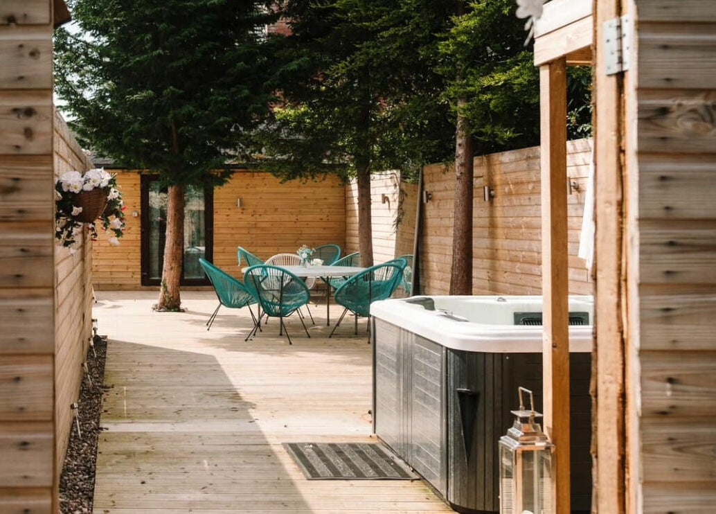 Outdoor spa area at Achill Spa in Knowle, England, GB with seating and wooden fences.