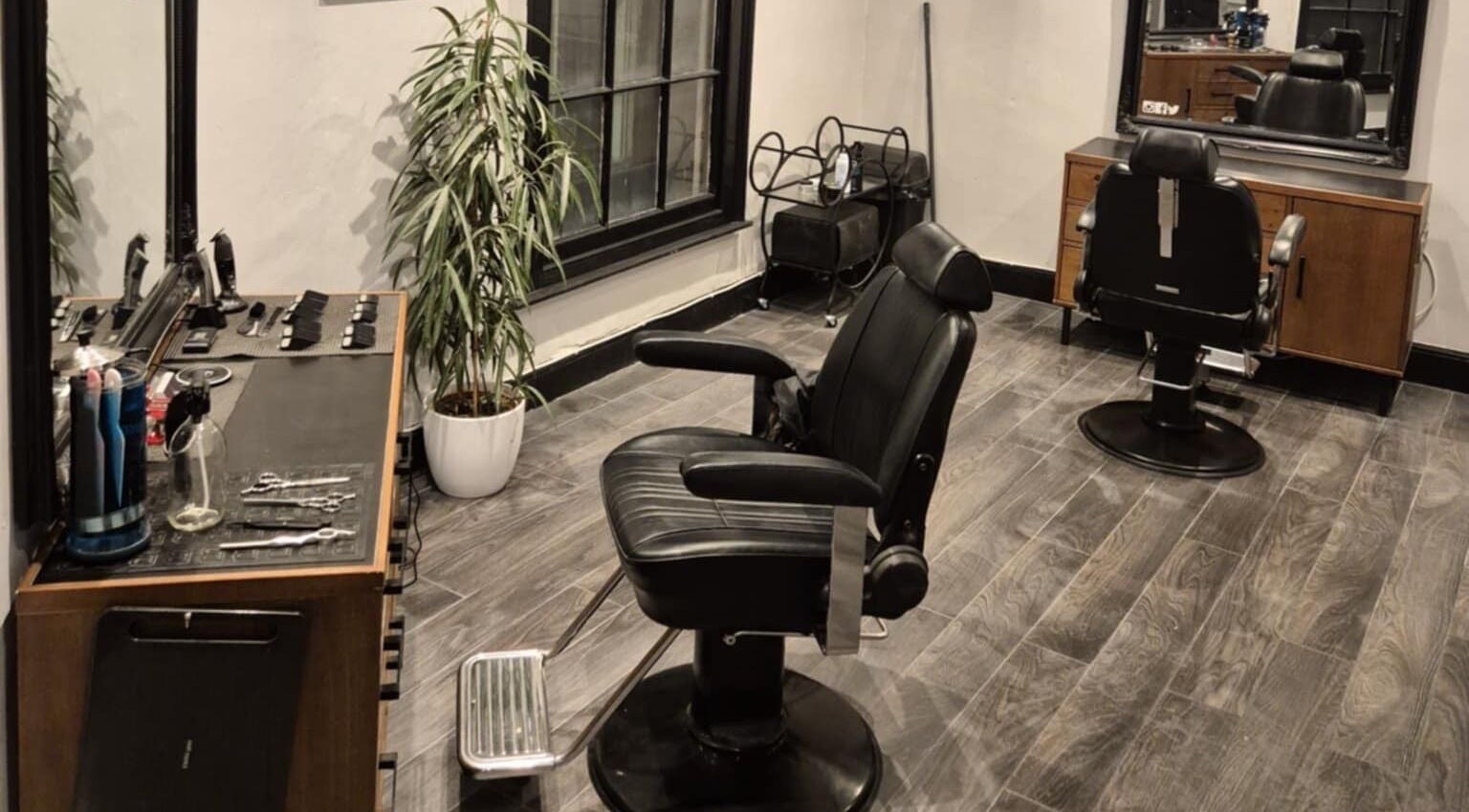 Elegant interior of The Attic Barbershop in Norwich, England, GB featuring modern chairs and stylish decor.