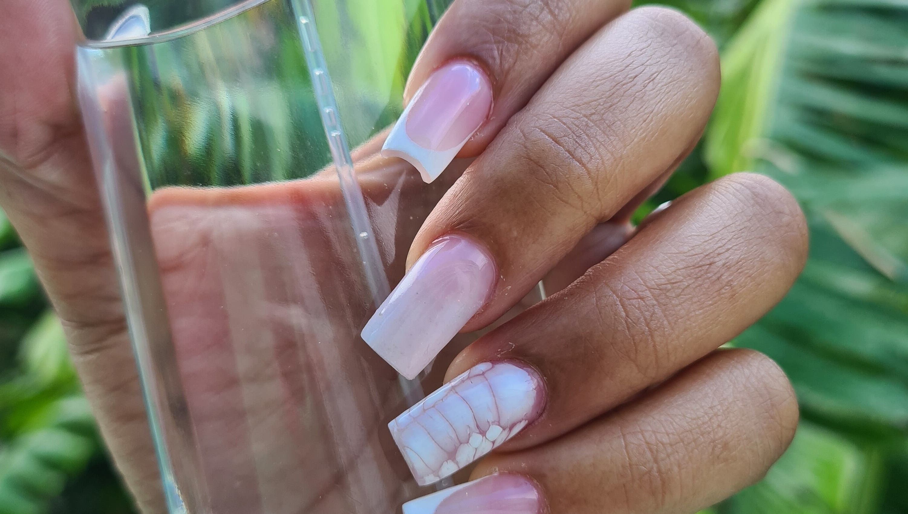 Beautiful pink and white French nails at The Nail Spot, Roseau, DM, showcasing exquisite manicure artistry.