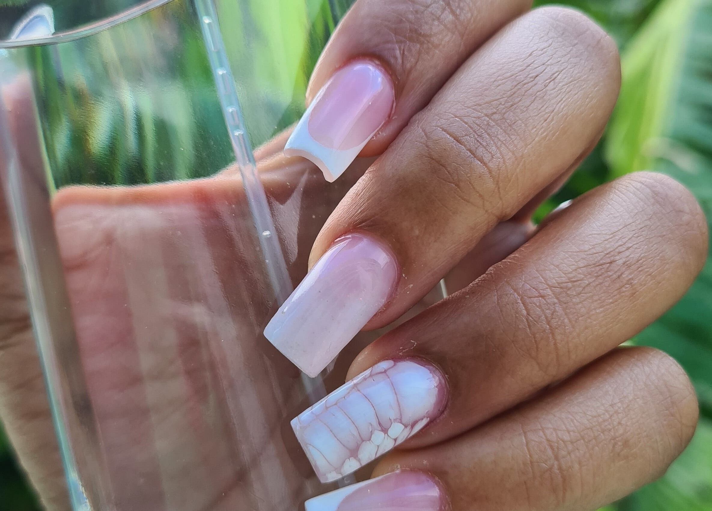 Beautiful pink and white French nails at The Nail Spot, Roseau, DM, showcasing exquisite manicure artistry.